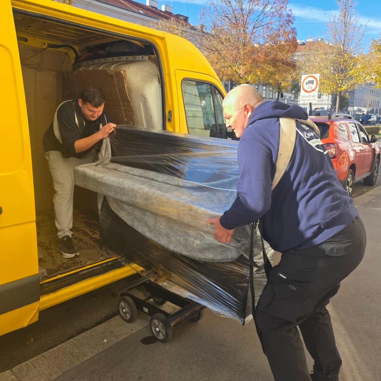 Klaviertransport Schwechat: verpacktes Klavier wird von der Straße in den Transporter geladen