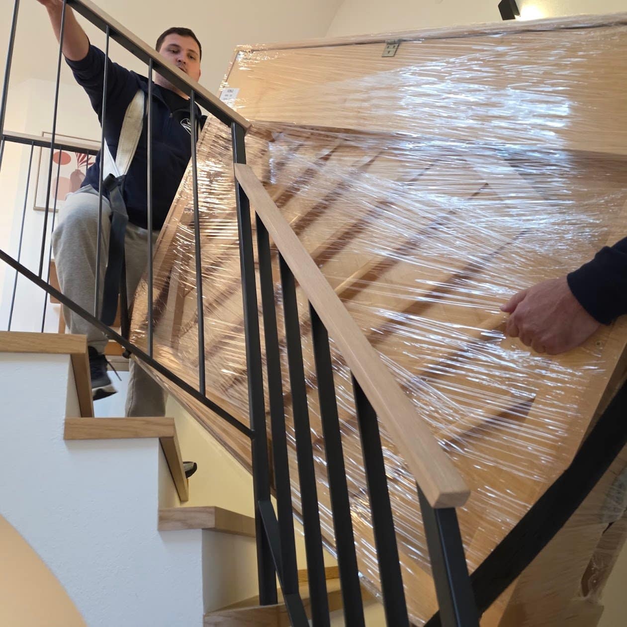 Piano transport Stockerau: a wrapped piano tilted on the staircase between two floors