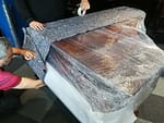A piano being packed for transport