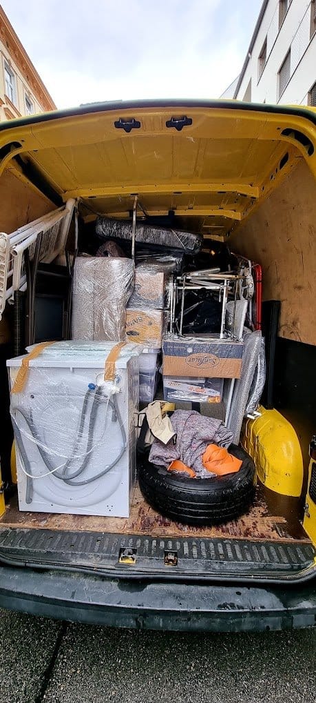 Beladener Transporter mit Waschmaschine, Matratze und Möbeln