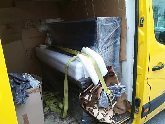 A piano secured with straps in the vehicle on the way to the delivery address