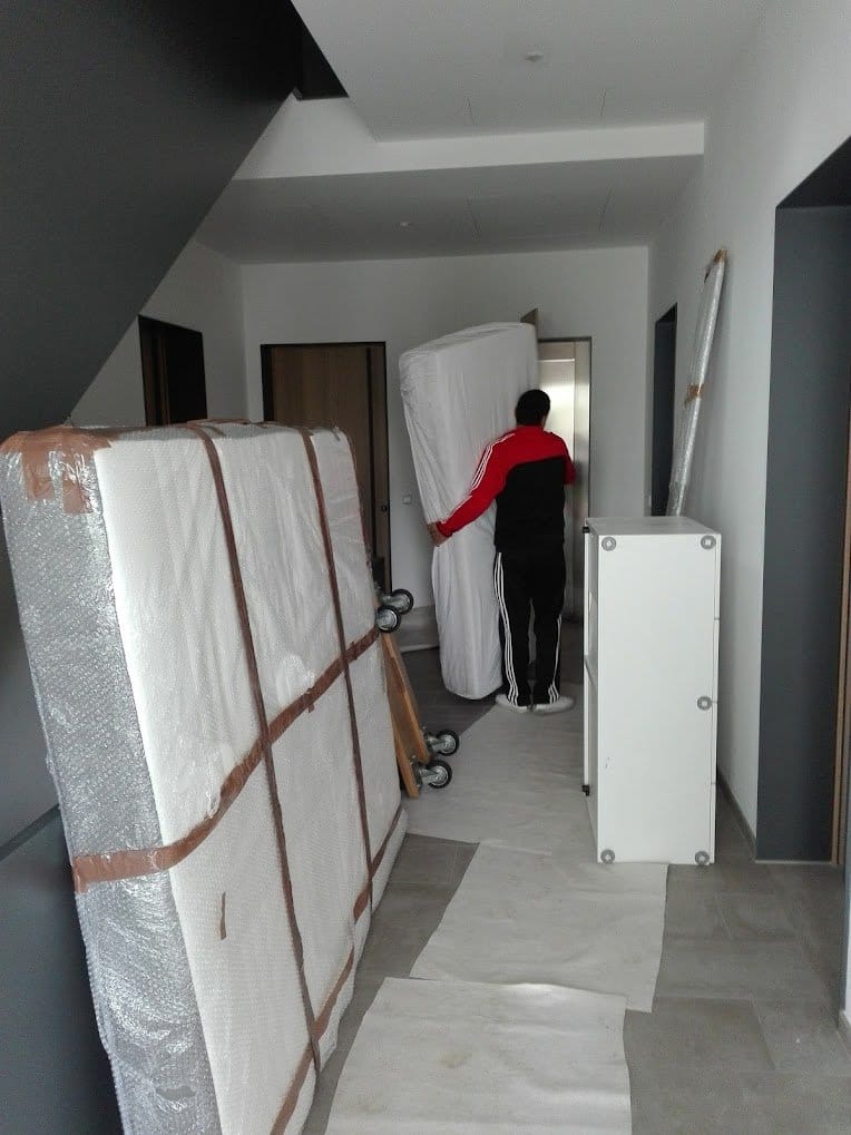Privatumzug in Wien: verpackte Matratze und Möbel im Stiegenhaus