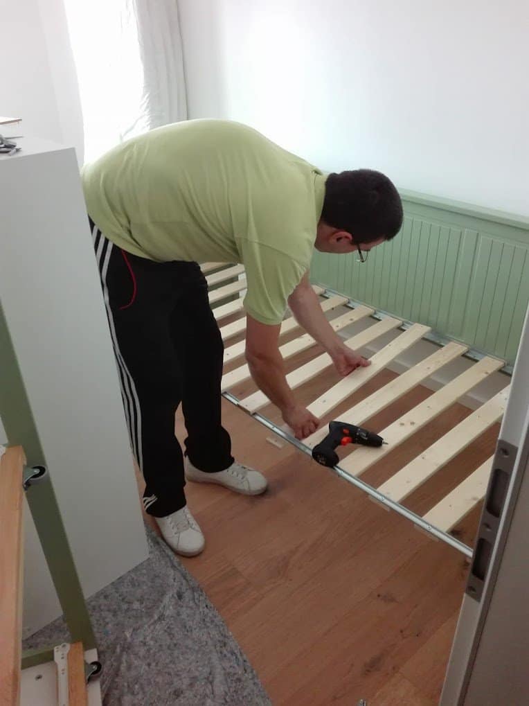 Möbelmontage beim Umzug: Monteur baut ein Bett am Zielort wieder auf