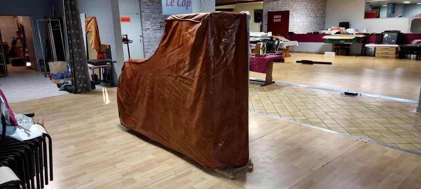 Grand piano wrapped and on its side for transport