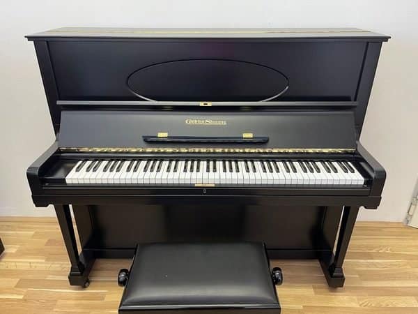 Ein schwarzes Klavier vor einer hellen Wand
